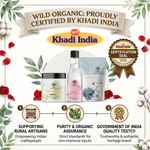 Promotional graphic for Khadi India products featuring three packaged items centered on a decorative white background with cotton plants, red rose petals, and certification seals. Text at the top reads 'WILD ORGANIC: PROUDLY CERTIFIED BY KHADI INDIA,' and three numbered callouts below highlight supporting rural artisans, purity/organic assurance, and government of India quality testing.