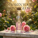 A clear glass bottle of Wild Organic Rose Water Salt Water with a pink label and dark cap, set on a marble surface surrounded by pink roses and petals in a sunlit garden. Large text reads 'Awaken Your Skin's Glow' and smaller text at the bottom reads 'Wild.