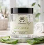 A jar of Wild Organic Pure & Natural Aloevera Gel, featuring a clear container, white label, and black lid, styled with fresh aloe vera slices on a light surface with a soft, blurred bathroom background.