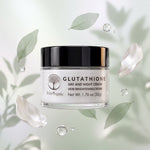 A jar of Wild Organic Glutathione Day and Night Cream centered against a soft, light green background with floating green leaves, petals, and water droplets. The jar has a black lid and a clear body showing the cream inside.